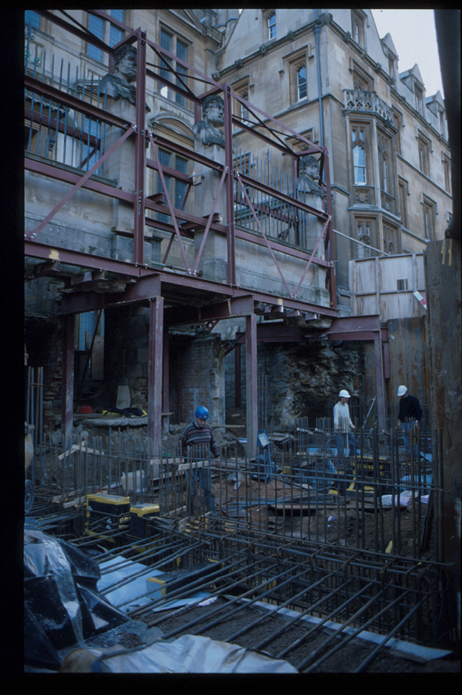 The outside of the Museum during extensive renovations in 1999. The ground in front of the Museum has been dug up, and the photo is taken from the hole while looking up to the Museum. The front wall is held up on metal stilts.