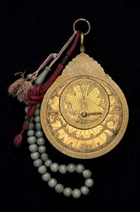 Astrolabe with green prayer beads and red cloth handle. 